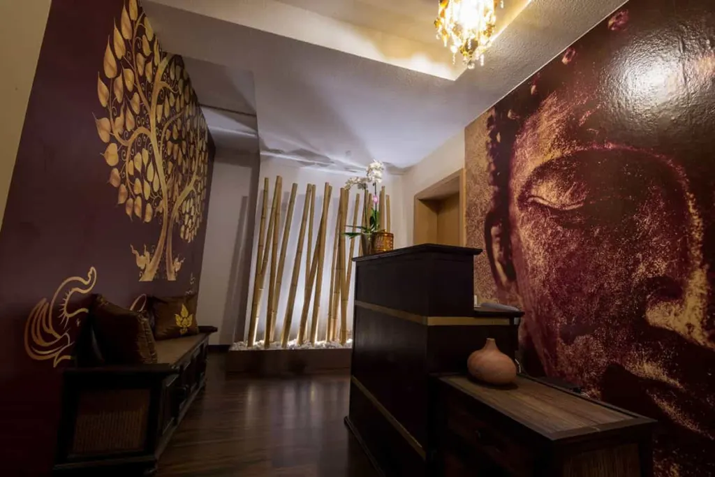 Empfang von Thaimassage Erawan in Frankfurt mit Buddha-Wandbild, goldenem Baum und Bambus